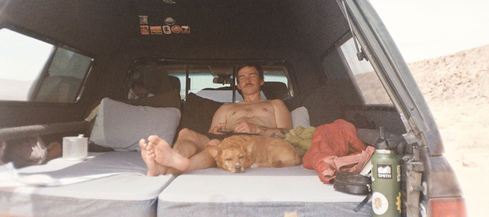 man lying on HEST Dually mattress in the back of his car