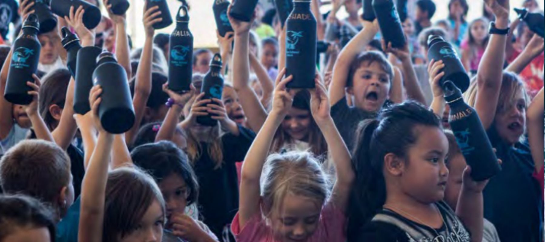 children holding up resuable water bottles 