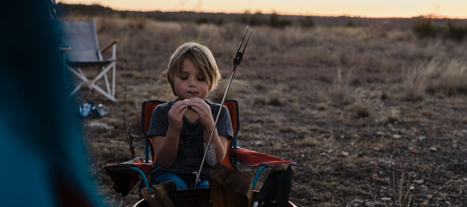 kid eating smores during desert sunset