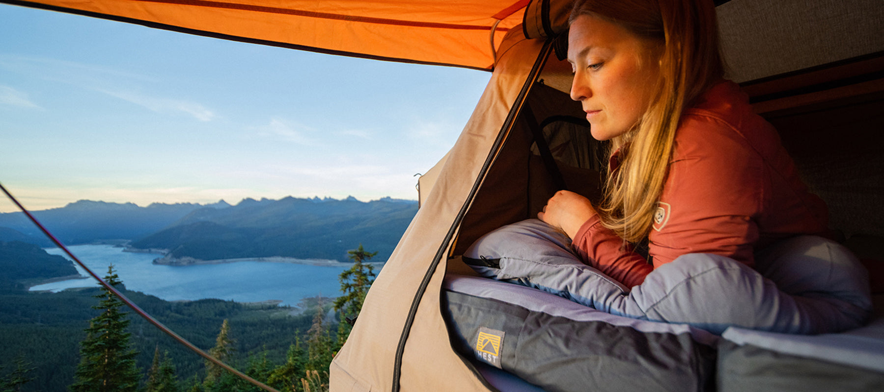 female looking out of her tent ontop of a HEST memory foam sleeping pag