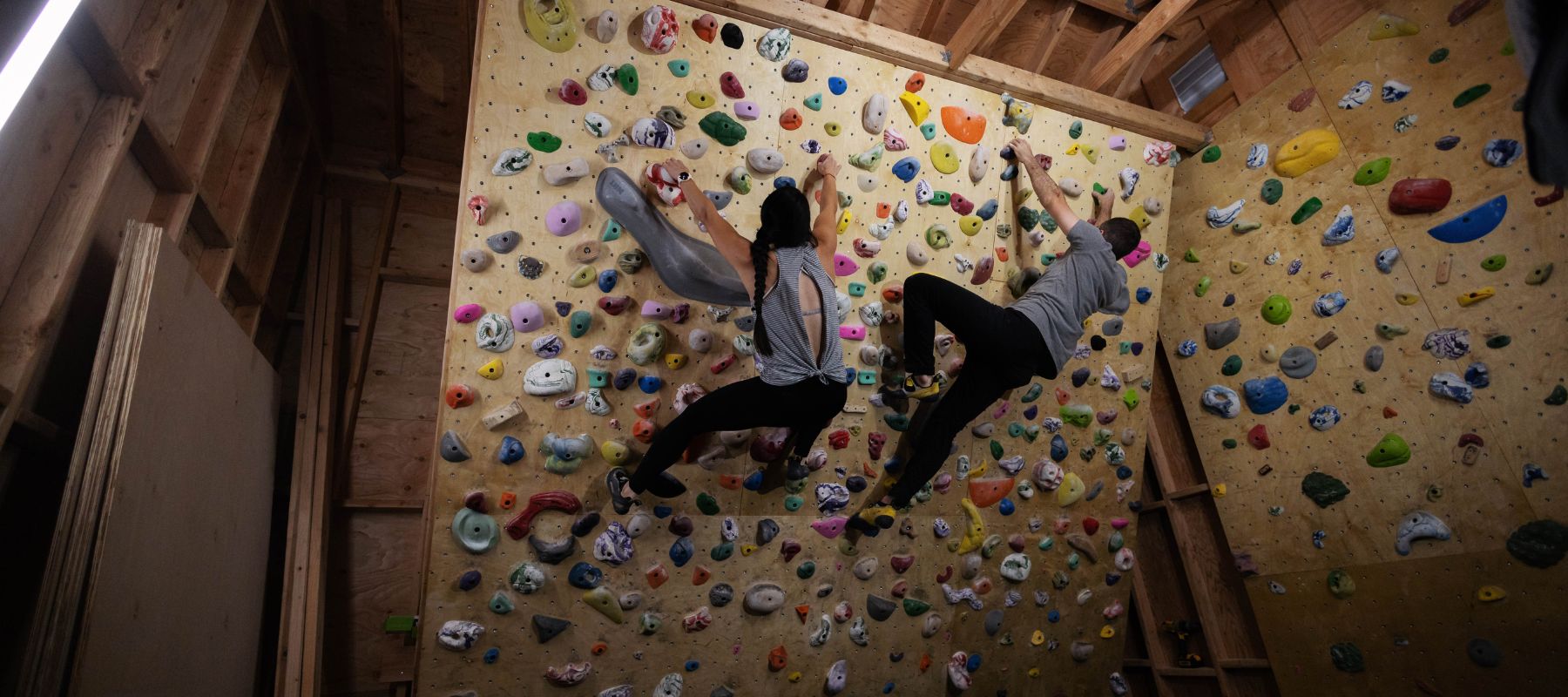 two people climbing on DIY rock wall 