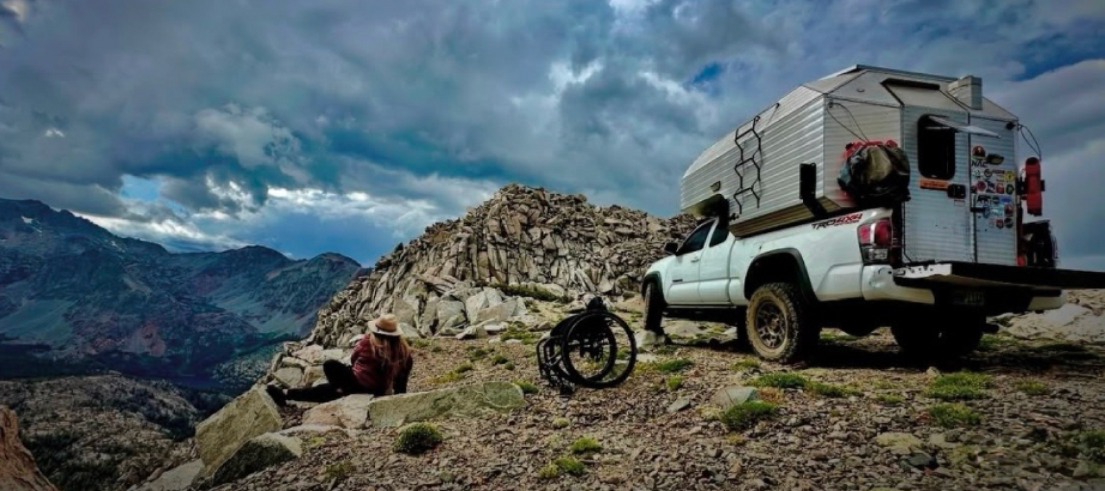 Channing’s 2023 Toyota Tacoma overland build parked in the mountains with an aluminum hard-sided truck camper, built for off-road camping and long-term adventure travel.