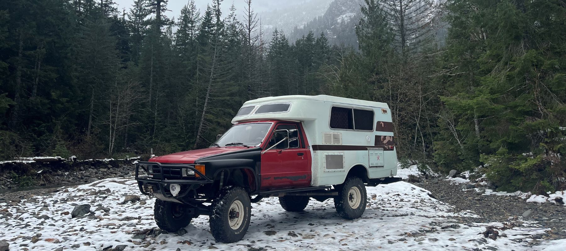 1985 Toyota Pickup Truck with Built in Camper parked on snowy lot