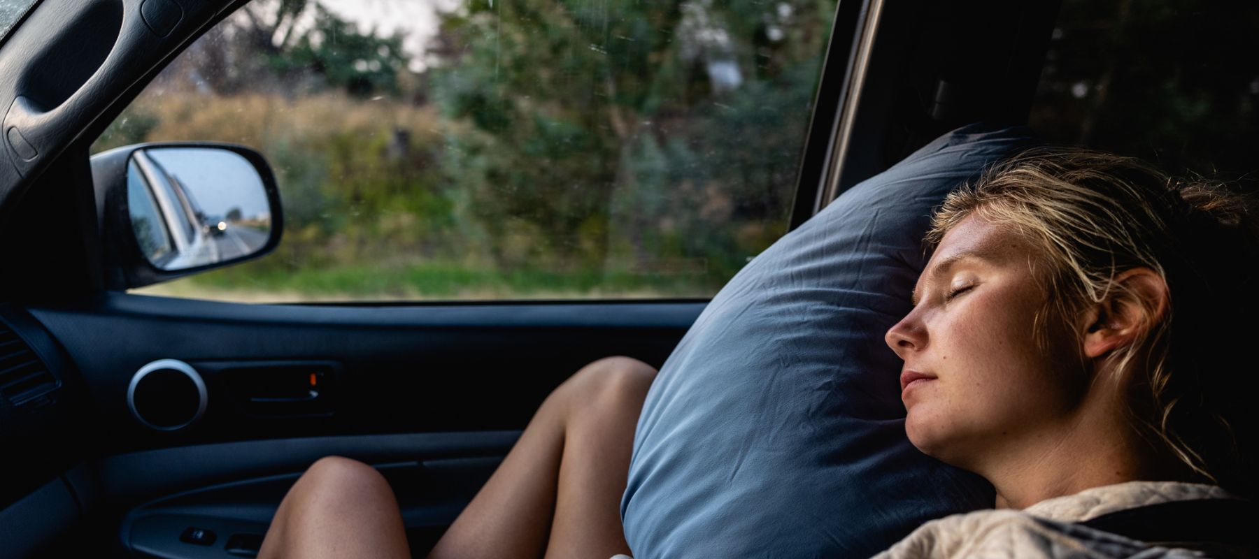 Woman sleeping on HEST pillow on car ride
