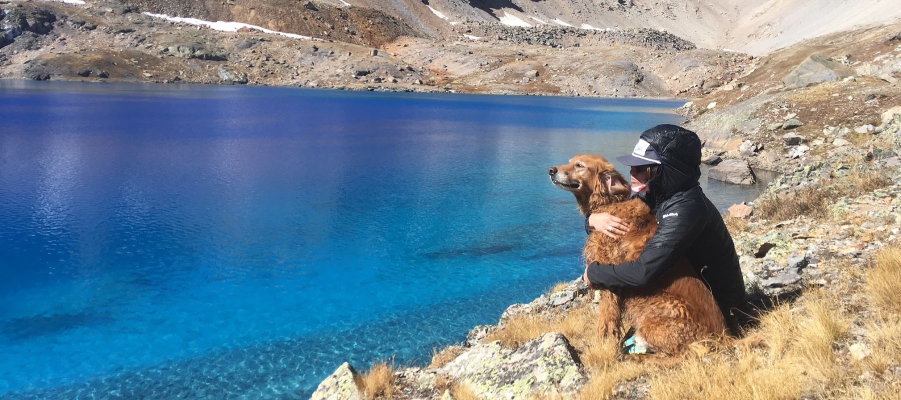 Dog and its owner overlooking lake in Colorado